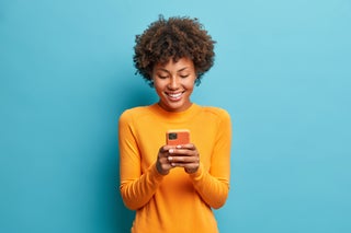 Woman smiles when looking at phone