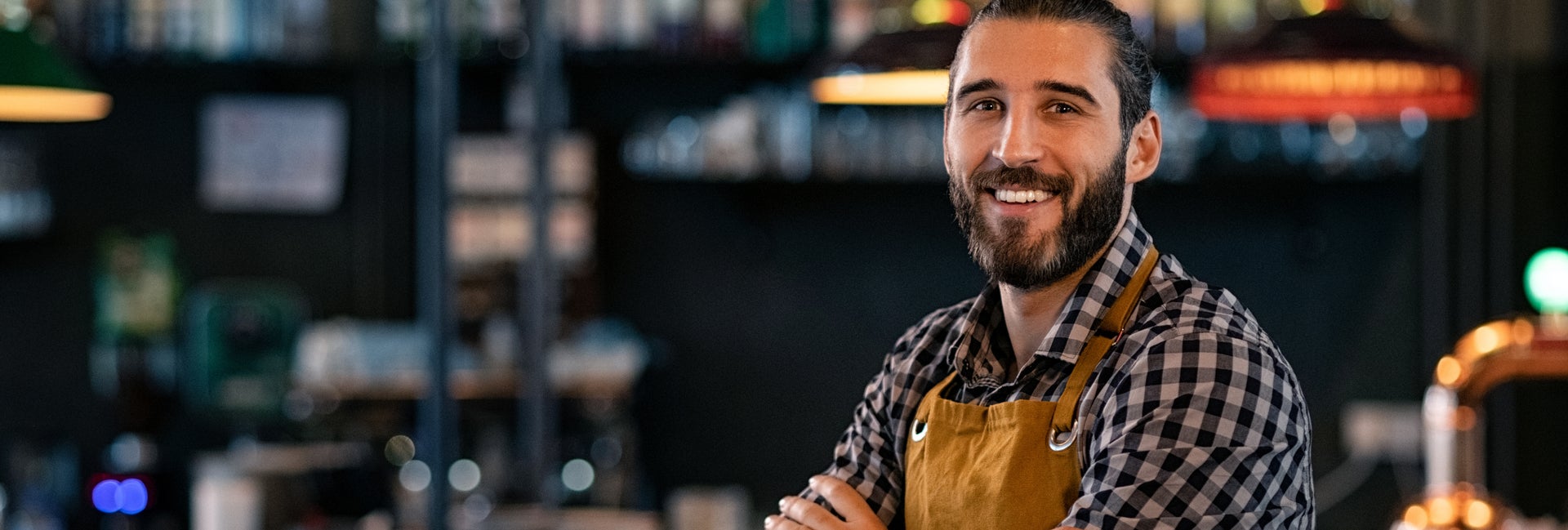 Man smiling in front of a bar