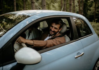 Man driving new blue car