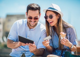 Couple eating ice cream holding credit card and smiling