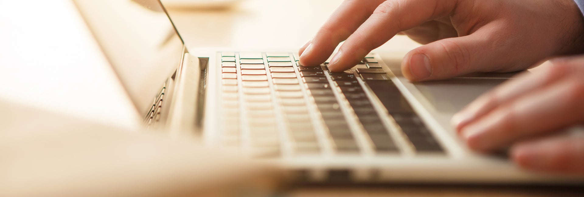 Hands typing on laptop computer