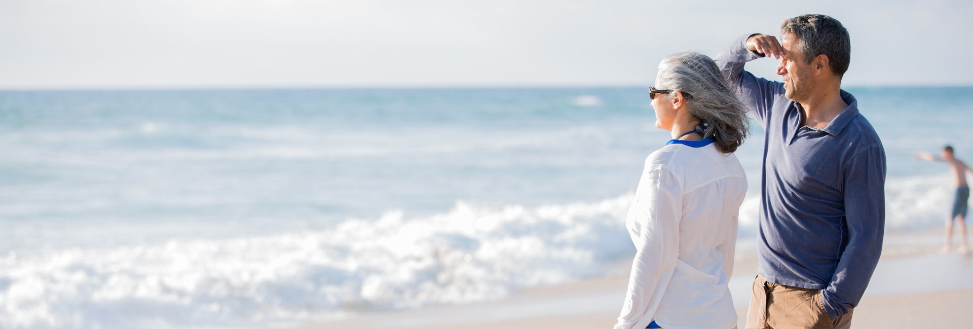 Couple on beach looks at ocean