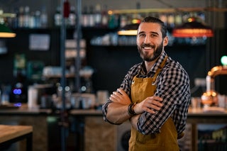 Man smiling in front of a bar
