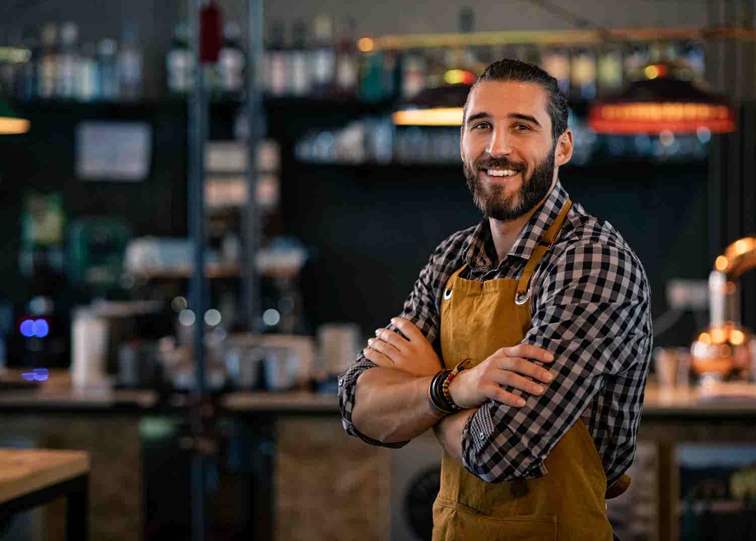 Man smiling in front of a bar