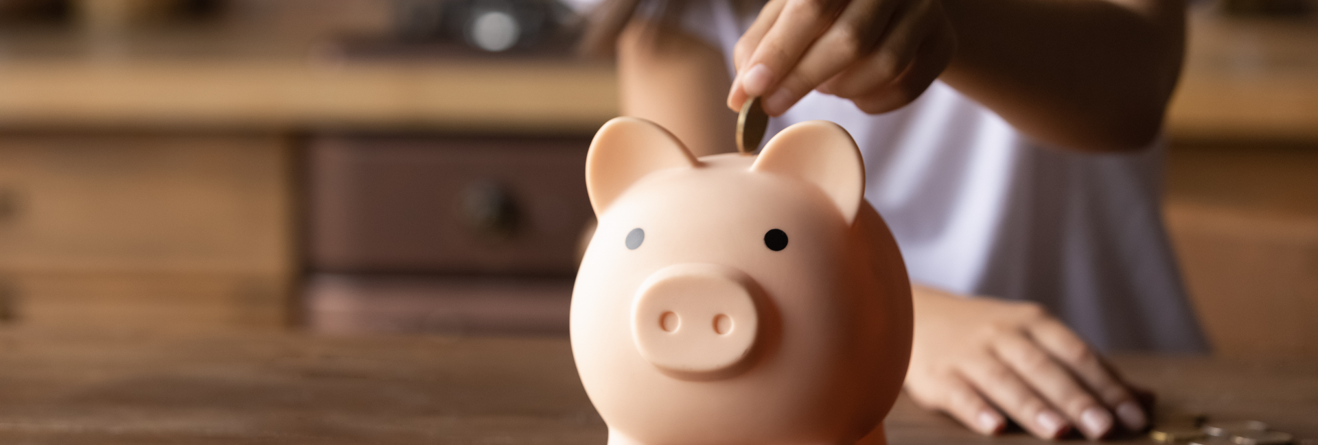 Girl puts coins in piggy bank