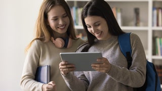 Two girls watch shows on a tablet