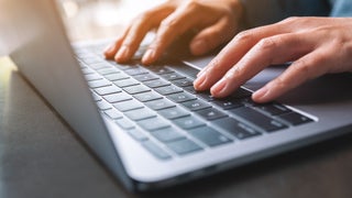 Hands typing on a laptop