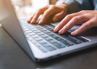 Hands typing on a laptop