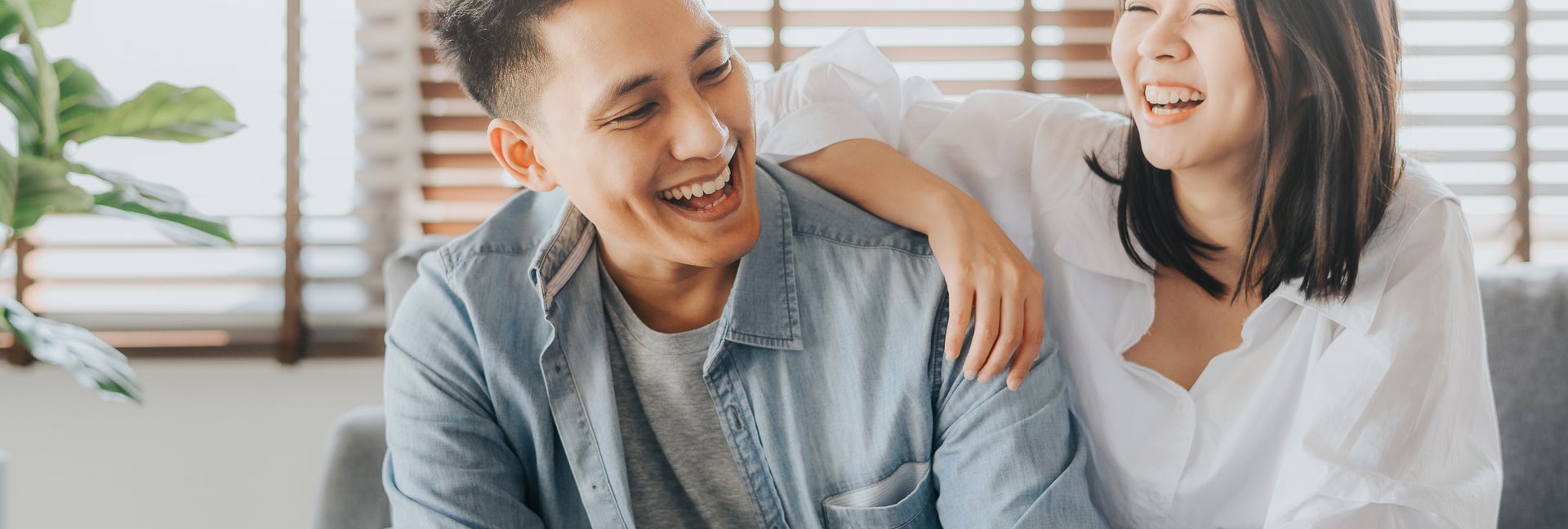 Couple laughing while sitting on couch