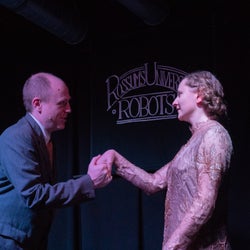 Domin (Aaron Collier) meets Helena Glory (Eva Ptašková) for the first time.