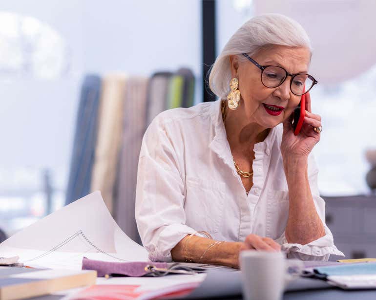 A senior Caucasian woman is taking a call during a work meeting. If you’re an older adult looking for employment, learn more about the job training and placement program SCSEP.