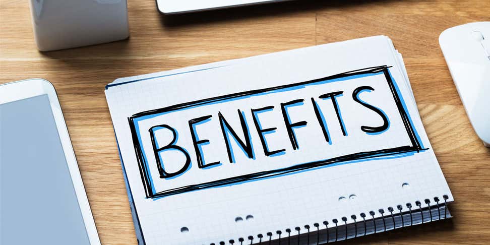 The word "Benefits" written on a notebook that's on an office table.