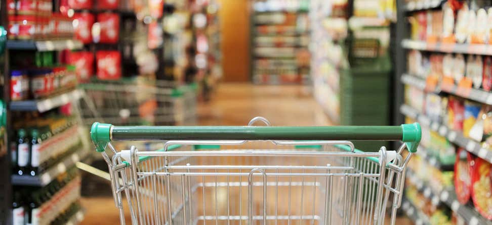 An empty grocery cart is in the middle of an aisle waiting to be filled. Use SNAP to reduce your net income through qualified deductions.