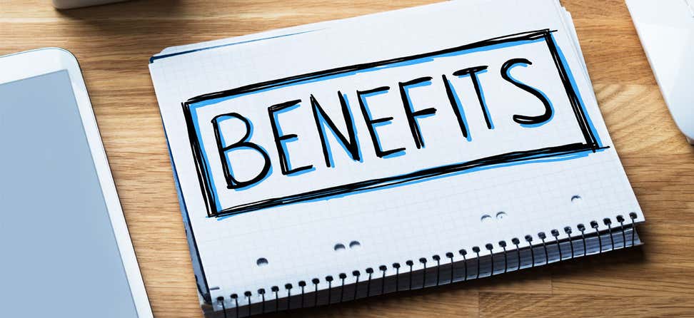 The word "Benefits" written on a notebook that's on an office table.