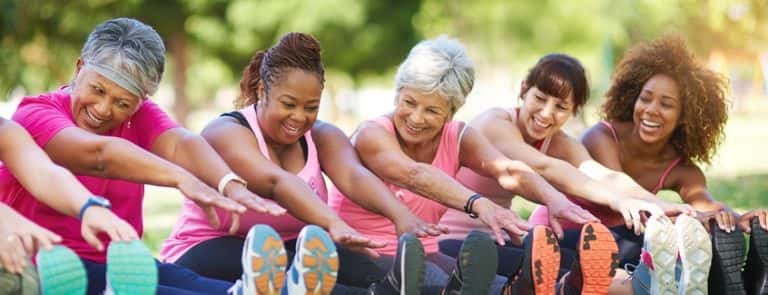 diverse group of older women stretching outside