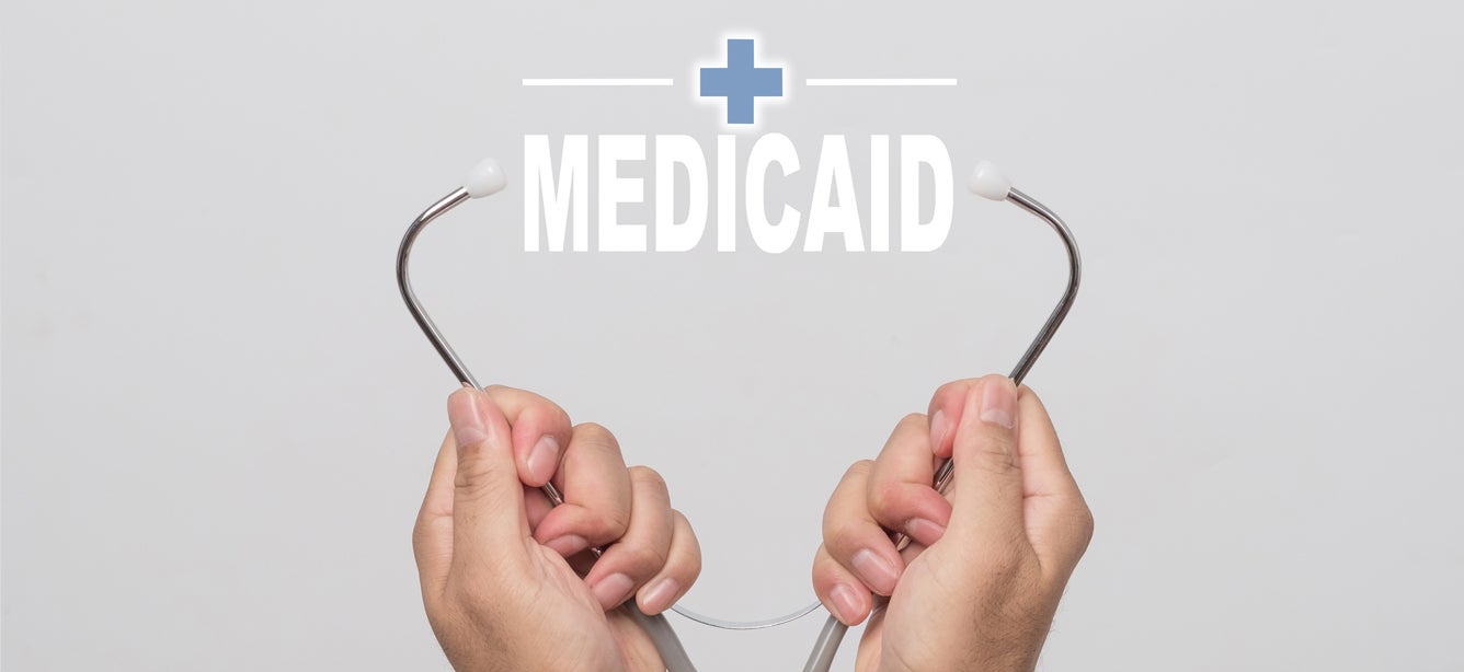 A stethoscope is pictured, opened, with the words "Medicaid" in between.