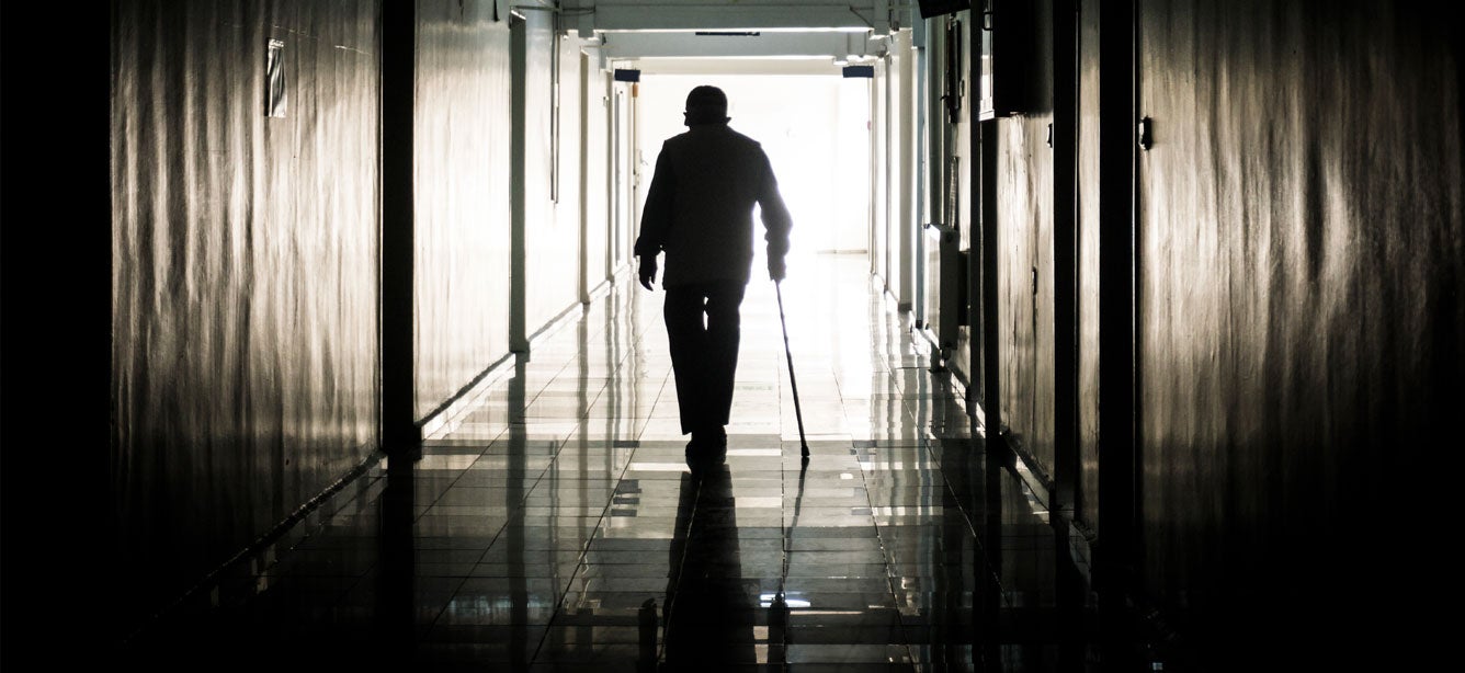 A disabled man using a cane is seen leaving a nursing home.
