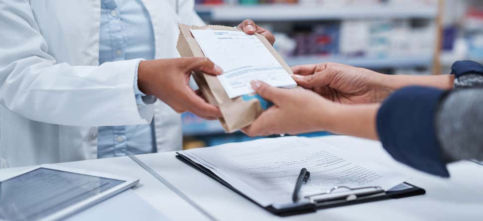 A closeup shot of a pharmacist assisting a customer with their prescription.