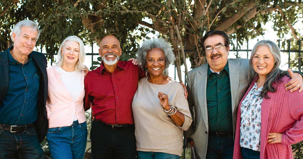 A multi-ethnic group of seniors poses for a group photo.