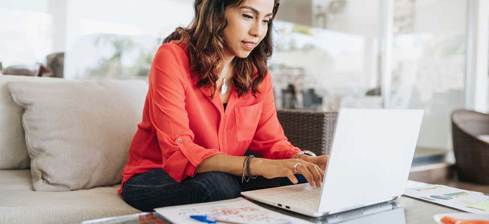 Older Latina woman working on a laptop computer