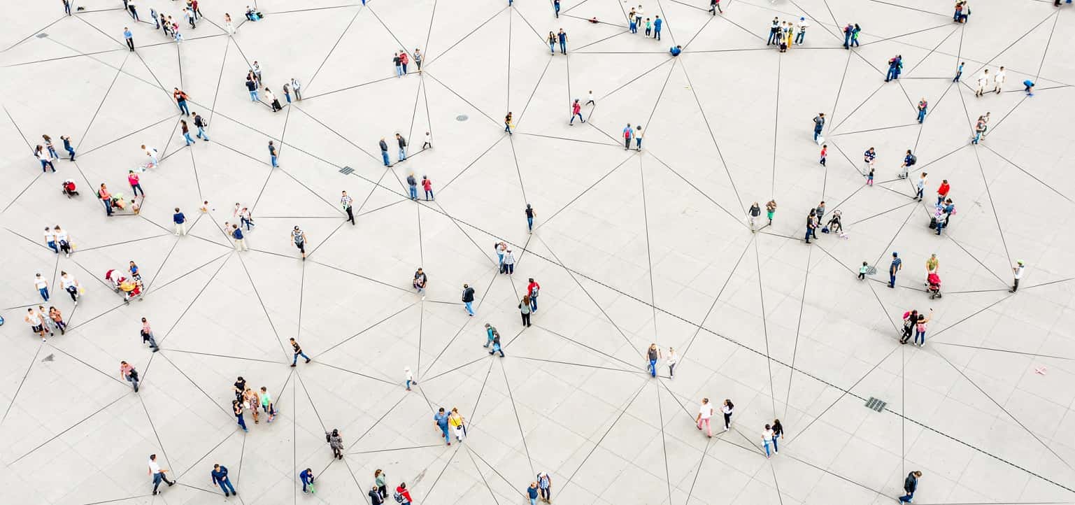 An aerial view of people walking around connected by lines, indicating a network.