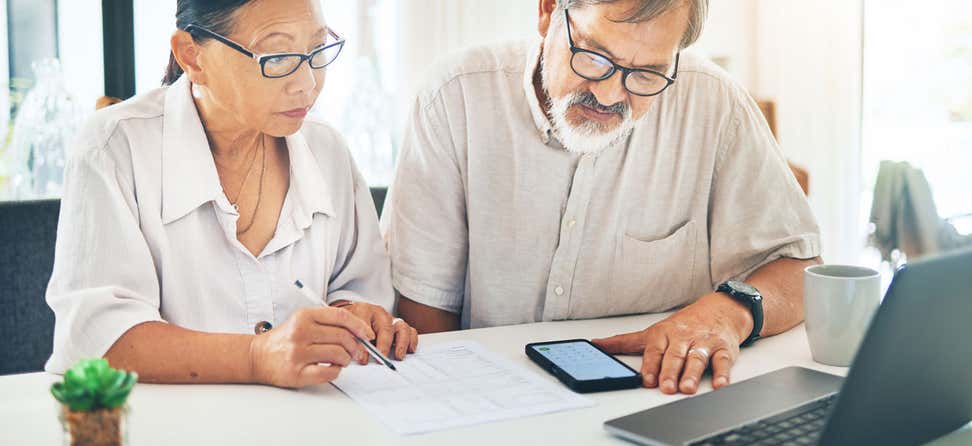 A senior woman of what looks to be native descent is looking at a qualified health plan with her partner who is a man. What is a QHP? Find out how these plans may help you get the coverage you need before you become Medicare-eligible.