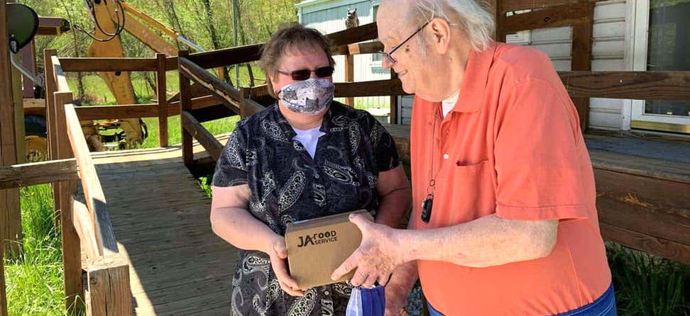 senior caucasian man receives a meal delivery at home during COVID pandemic