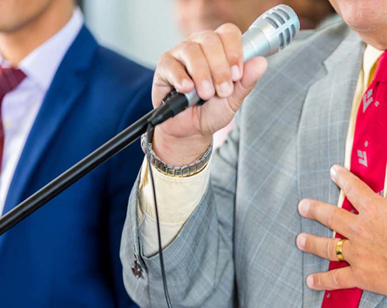 Close up shot of a public citizen speaking into the microphone at a public townhall.