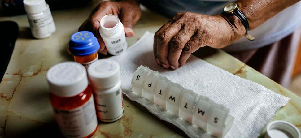 Senior sorts through daily prescriptions and places them into a daily pill container.