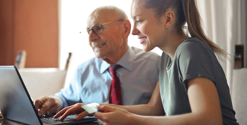 A younger professional helps a senior with Medicare. 