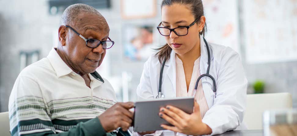 Senior black man consults with doctor using a tablet.