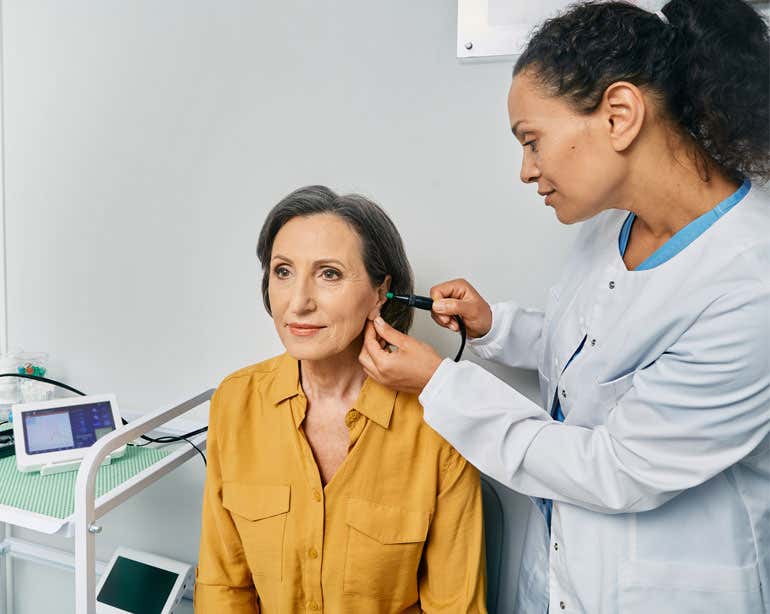 A senior caucasian woman is getting a hearing exam.